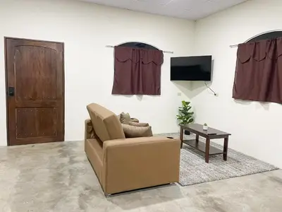 a living room with a chair and a tv at Tres Cielos Cabañas in San Pedro Masahuat