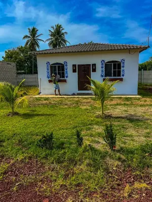 a man standing in front of a house at Tres Cielos Cabañas in San Pedro Masahuat