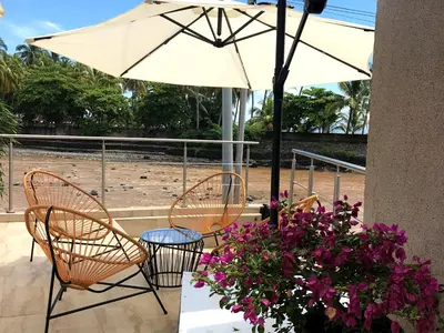 a patio with a table and chairs and an umbrella at VUE by The Cabins in La Libertad