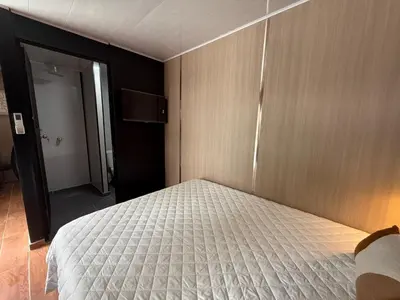a bedroom with a bed and a door to a bathroom at VUE by The Cabins in La Libertad