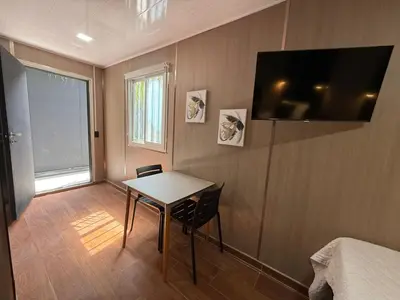 a room with a table and a bed and a television at VUE by The Cabins in La Libertad