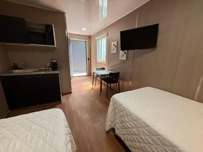 a hotel room with two beds and a sink and a table at VUE by The Cabins in La Libertad