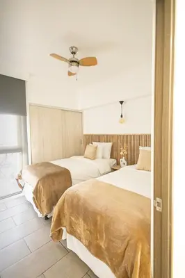 two beds in a hotel room with a ceiling fan at Modern Apartment 2 Bedrooms 2 Bathrooms WIFI in Las Delicias