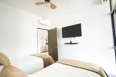 a hotel room with two beds and a flat screen tv at Modern Apartment 2 Bedrooms 2 Bathrooms WIFI in Las Delicias