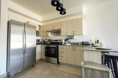 a kitchen with wooden cabinets and a stainless steel refrigerator at Modern Apartment 2 Bedrooms 2 Bathrooms WIFI in Las Delicias