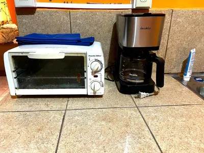 a microwave sitting on a counter next to a coffee maker at Casa de Montaña en Los Naranjos in Los Naranjos