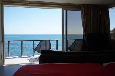 a room with a balcony with a view of the ocean at Casa de Mar Hotel And Villas in La Libertad