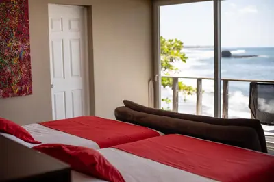 a bedroom with two beds and a view of the ocean at Casa de Mar Hotel And Villas in La Libertad