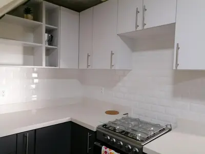 a white kitchen with a stove and white cabinets at Casa en zona privada in San Salvador