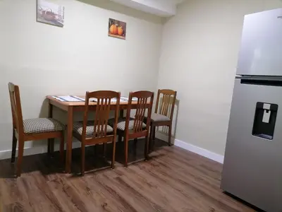 a kitchen with a table and chairs and a refrigerator at Casa en zona privada in San Salvador