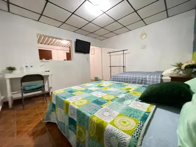 a bedroom with a bed with a quilt on it at Tunco Bambú Room 1 in Tamanique