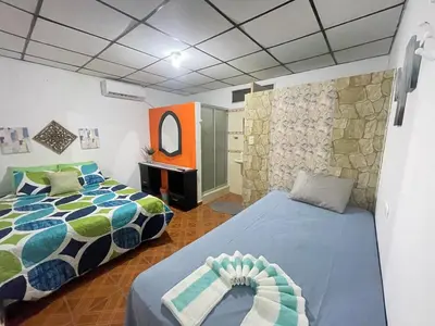 a bedroom with two beds and a mirror in it at Tunco Sun Room 2 in Tamanique