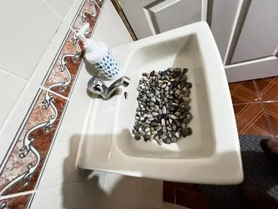 a white sink filled with rocks in a bathroom at Tunco Sun Room 2 in Tamanique