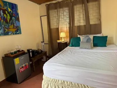 a bedroom with a large white bed with green pillows at Casa DUNA 3 in Playa San Blas