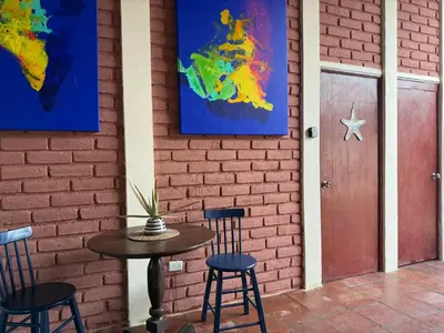 a table and chairs next to a brick wall with a door at Casa DUNA 3 in Playa San Blas