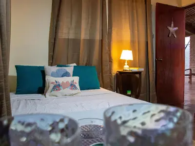 a bedroom with a bed with blue pillows at Casa DUNA 2 in La Libertad