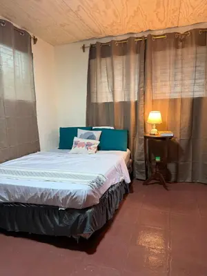 a bedroom with a bed and a table with a lamp at Casa DUNA 2 in La Libertad