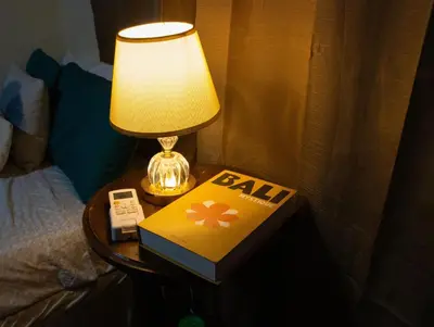 a lamp on a table with a book and a phone at Casa DUNA 2 in La Libertad
