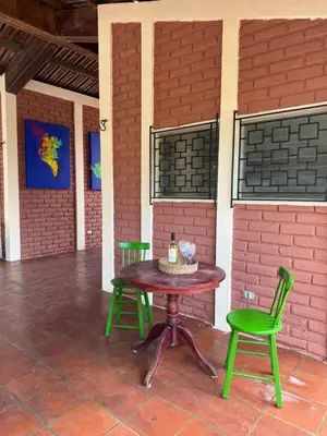 a table and two green chairs on a patio at Casa DUNA 2 in La Libertad