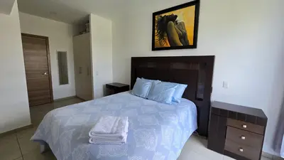a bedroom with a blue bed with towels on it at Acogedor y Centrico Apartamento in San Salvador