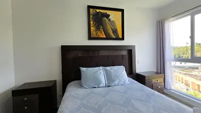 a bedroom with a bed and a picture on the wall at Acogedor y Centrico Apartamento in San Salvador