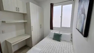 a small room with a bed and a window at Acogedor y Centrico Apartamento in San Salvador