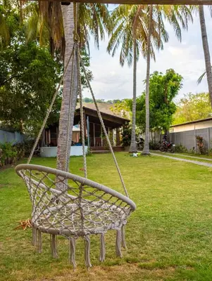 a swing hanging from a palm tree in a yard at Casa DUNA 4 in La Libertad