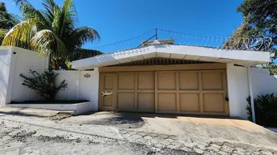 a garage door of a house with a palm tree at Casa Tropical Kaylani in Tamanique