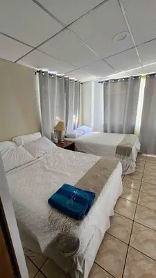 a hotel room with two beds with a blue folder on them at Casa Tropical Kaylani in Tamanique