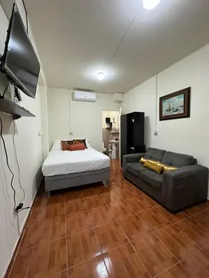 a living room with a bed and a couch at Cuarto estudio HERSOR in San Salvador