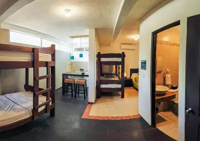 a room with bunk beds and a kitchen with a bathroom at Eco del Mar in La Libertad