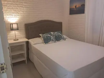 a bed with two pillows and a night stand with a lamp at La Cima House-Studio in San Salvador