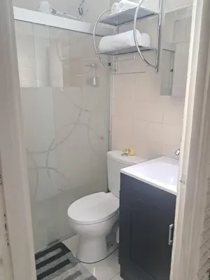 a white bathroom with a toilet and a sink at La Cima House-Studio in San Salvador