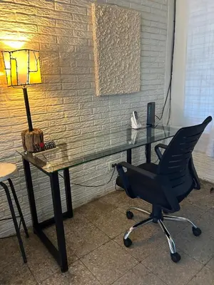 a glass desk with a lamp and a chair at La Cima House-Studio in San Salvador