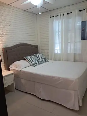 a bedroom with a large bed with a window at La Cima House-Studio in San Salvador