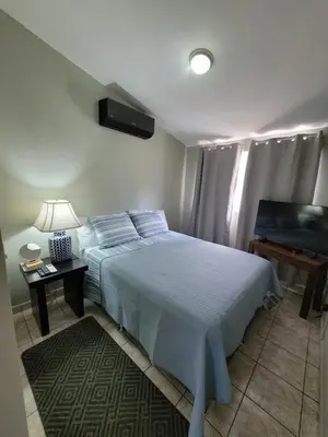 a bedroom with a bed and a table with a lamp at Familiar cómodo centrico in San Salvador
