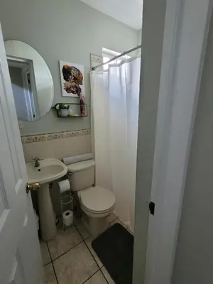 a bathroom with a toilet and a sink and a mirror at Familiar cómodo centrico in San Salvador
