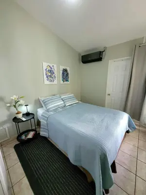 a bedroom with a large bed with a blue blanket at Familiar cómodo centrico in San Salvador