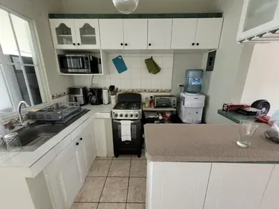 a kitchen with white cabinets and a stove at Familiar cómodo centrico in San Salvador