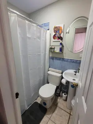 a bathroom with a white toilet and a sink at Familiar cómodo centrico in San Salvador