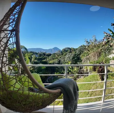a hammock on a balcony with a view of the mountains at Las Terrazas Suites Studio Apartment in San Salvador