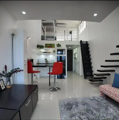a living room with a desk and red chairs at Las Terrazas Suites Studio Apartment in San Salvador