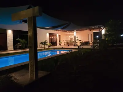 a house with a swimming pool at night at Residence in Salinitas, Los Cobanos in Los Cóbanos