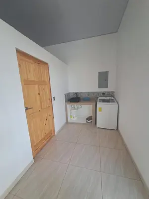 an empty room with a kitchen with a door at Residence in Salinitas, Los Cobanos in Los Cóbanos