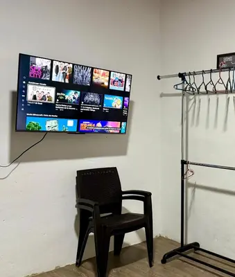 a chair in a room with a television on a wall at Tu Estancia en Sonsonate in Sonsonate
