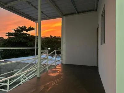 a balcony of a building with a sunset in the background at Tu Estancia en Sonsonate in Sonsonate