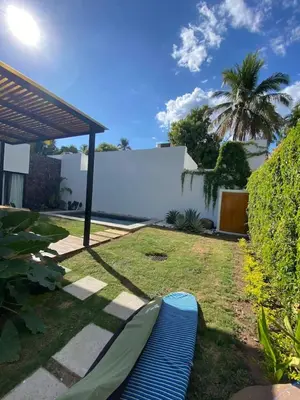 a backyard with a hammock in the grass at Villa Uma 50m to Zonte wave 2Bdr in El Zonte