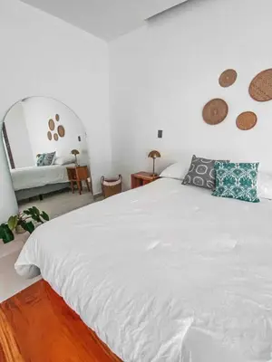 a bedroom with a large white bed and a mirror at Villa Uma 50m to Zonte wave 2Bdr in El Zonte