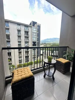 a balcony with a table and a view of a building at Apartamento amueblado Condado Santa Rosa Santa Tecla La Libertad in Nanastepeque