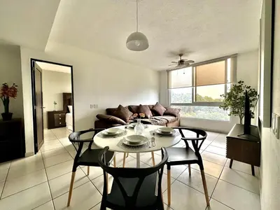 a living room with a table and a couch at Exclusive Apartment with Pool & Rooftop in El Salvador in San Salvador